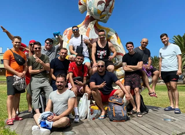 L'équipe Migen au complet, en photo de groupe devant une sculpture colorée