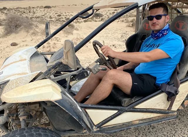 Un membre de l'équipe Migen au volant d'un buggy des sables