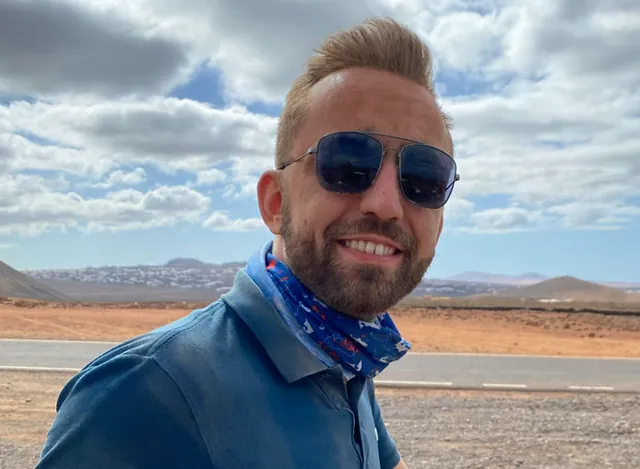 Un membre de l'équipe en foulard, paysage volcanique de Fuerteventura derrière lui