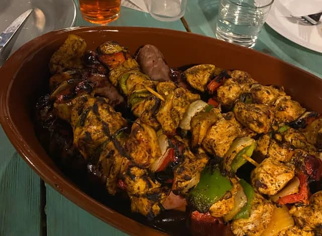 Plat de brochettes grillées partagé par l'équipe lors d'un repas