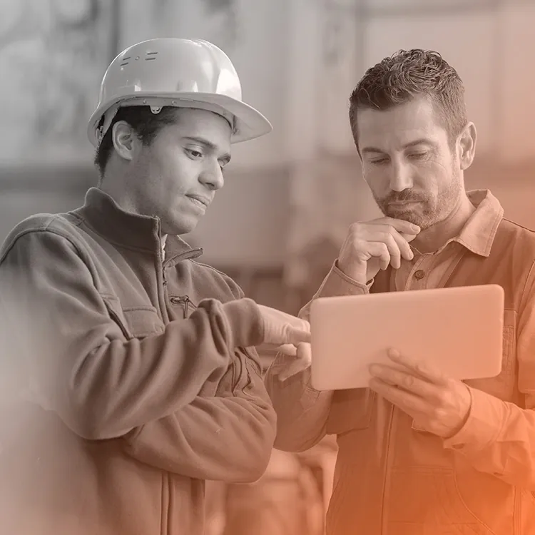 Deux techniciens consultent une tablette sur le terrain