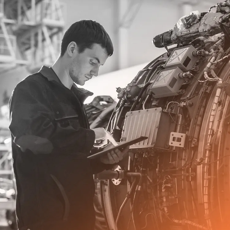 Technicien consultant une tablette devant une machine industrielle