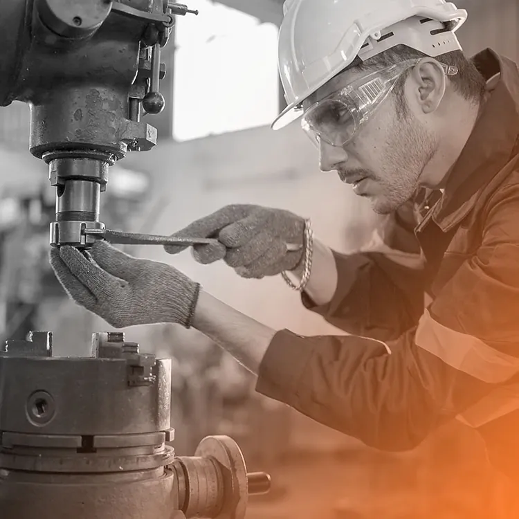 Mainteneur industriel casqué au réglage d'une machine-outil