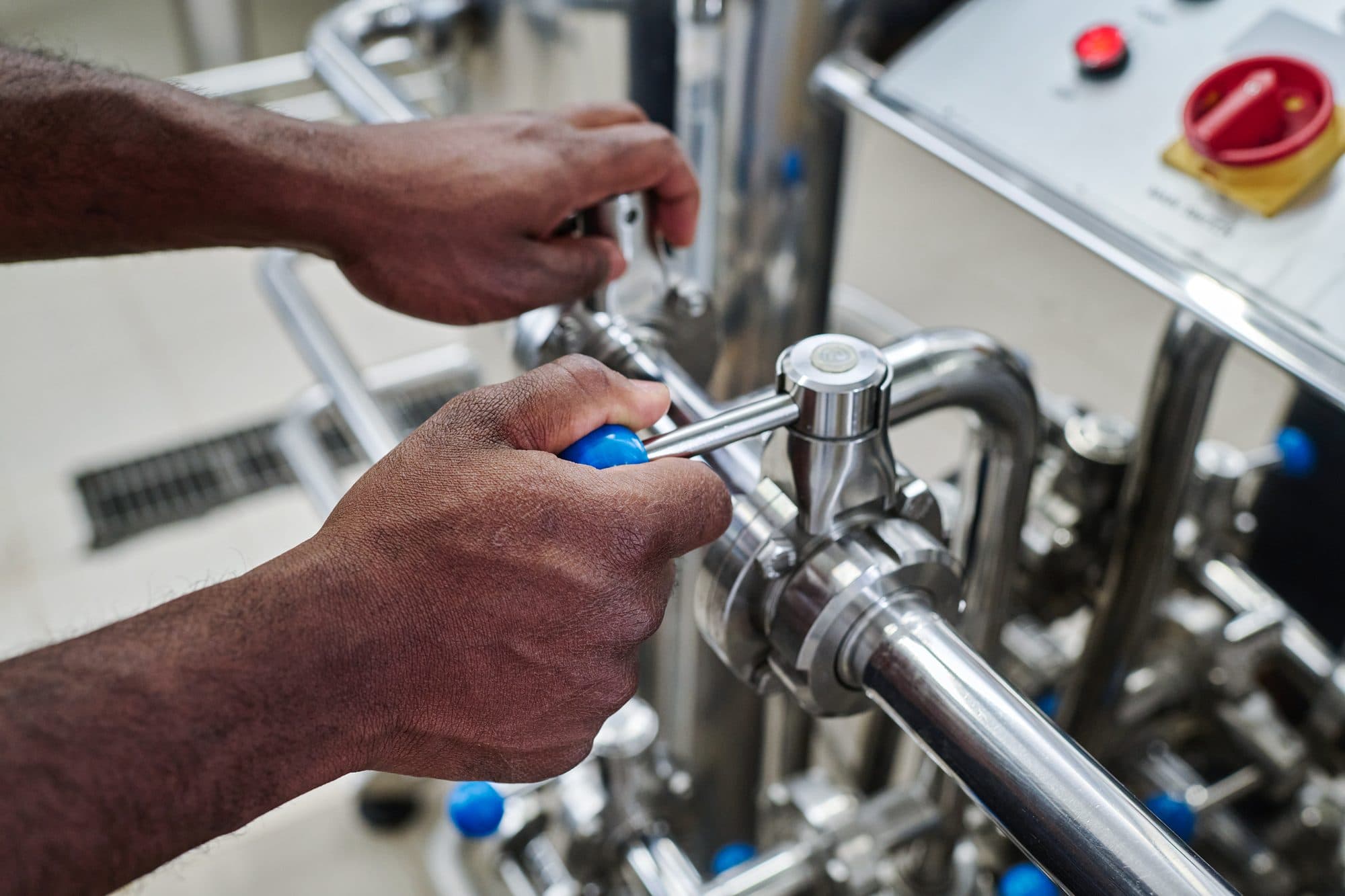 Mains réglant une vanne sanitaire inox au tournevis