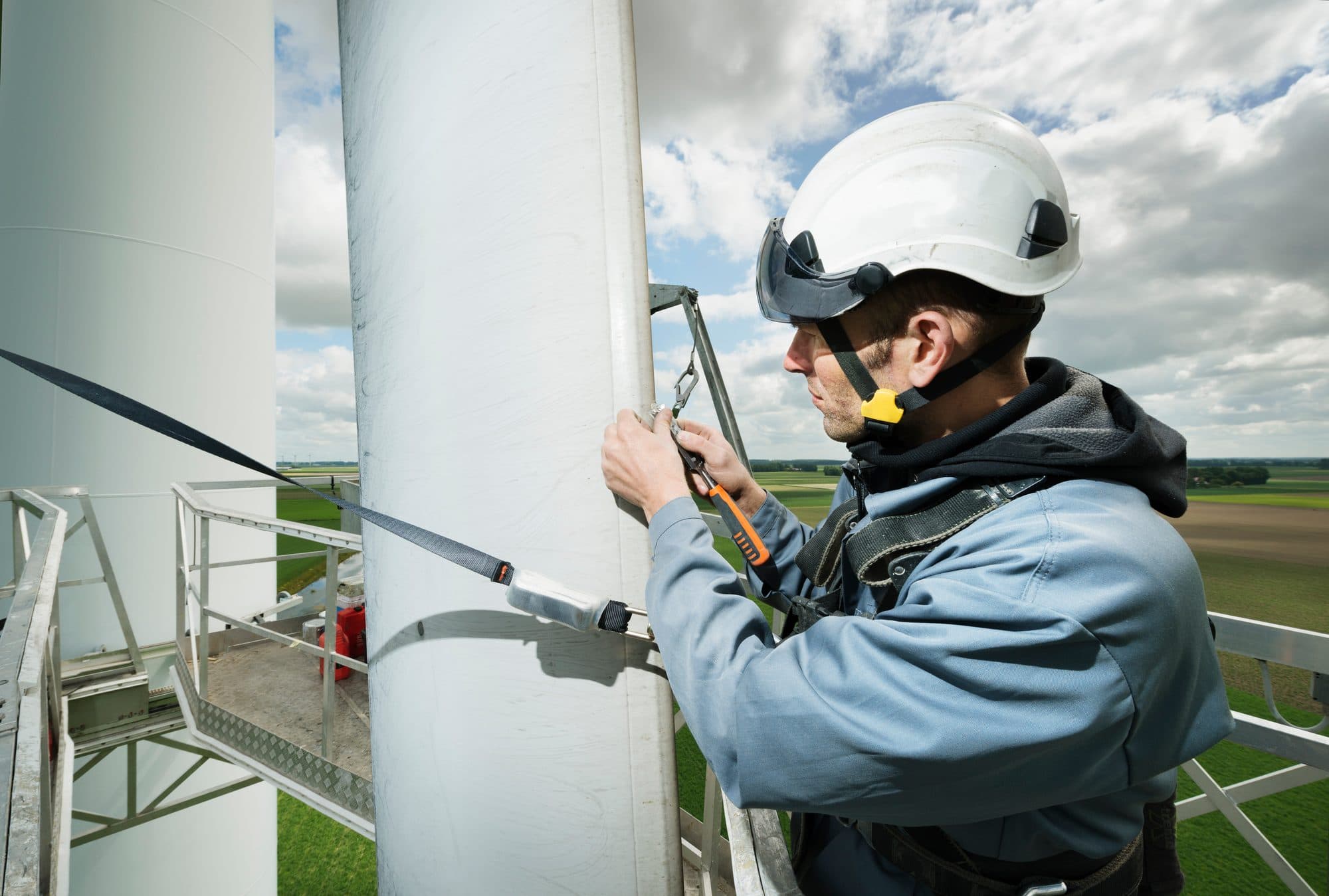 Technicien éolien en hauteur, harnais et longe