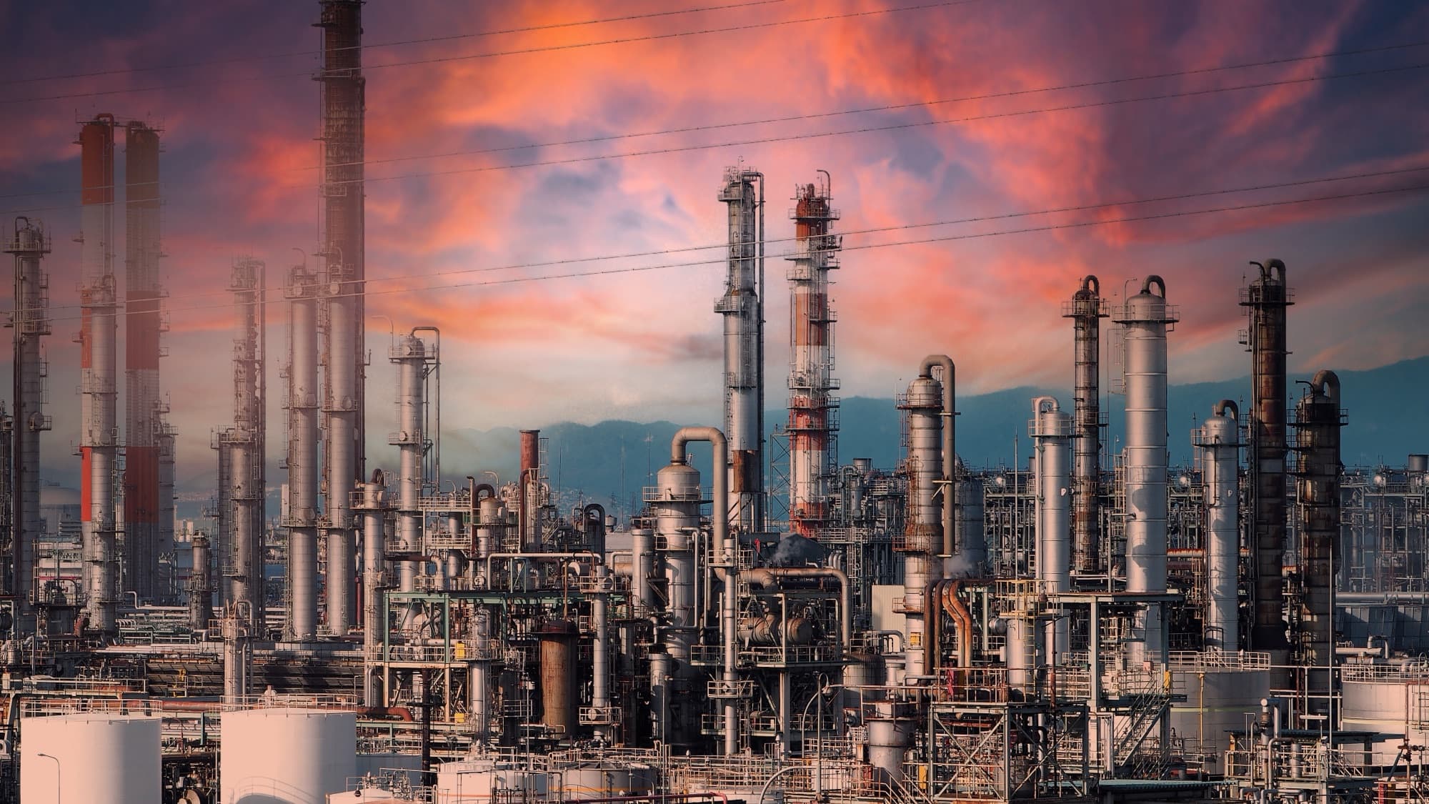 Raffinerie pétrochimique et ses colonnes de distillation sous un ciel de crépuscule