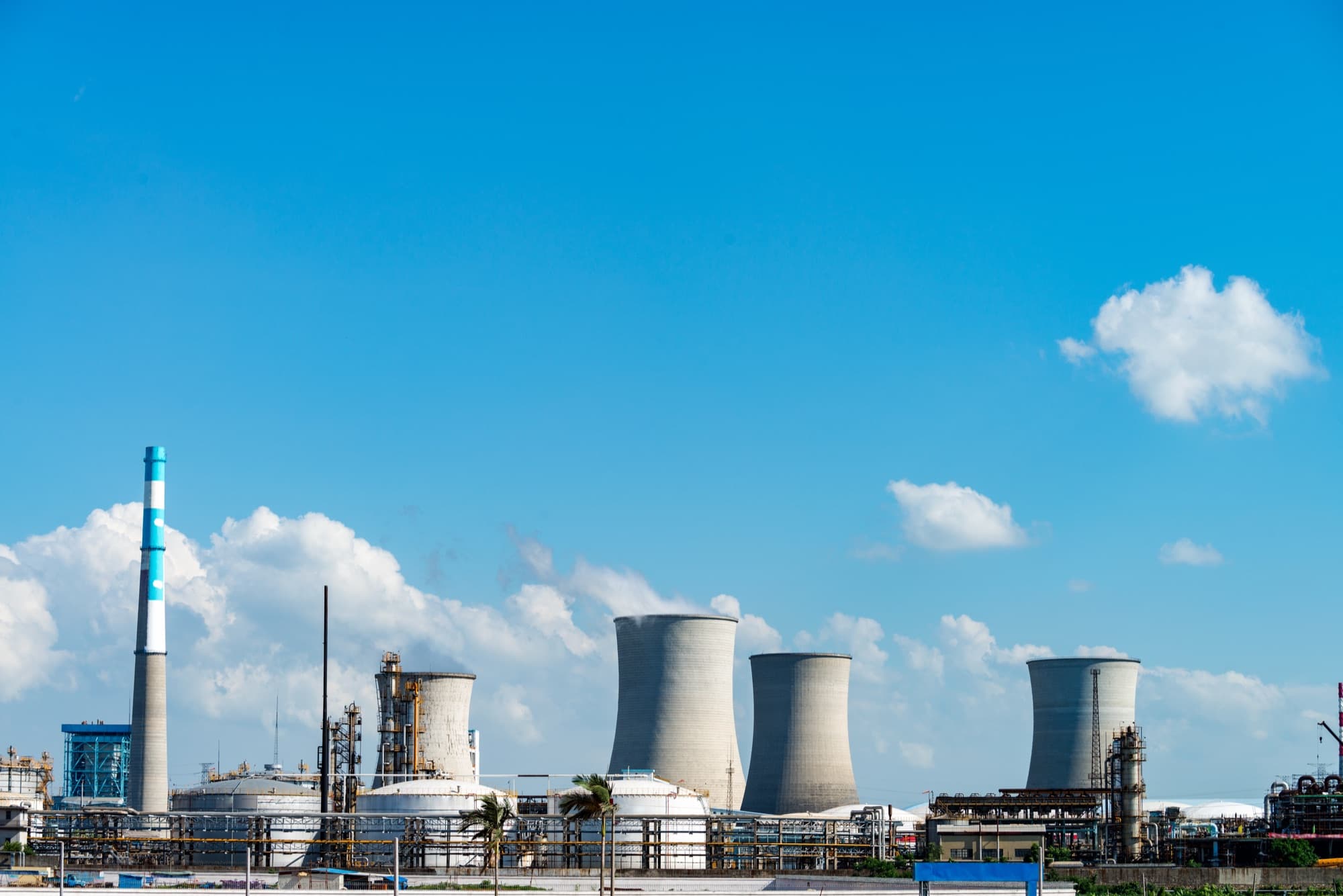 Tours aéroréfrigérantes et cheminées d'une centrale thermique sous un ciel bleu