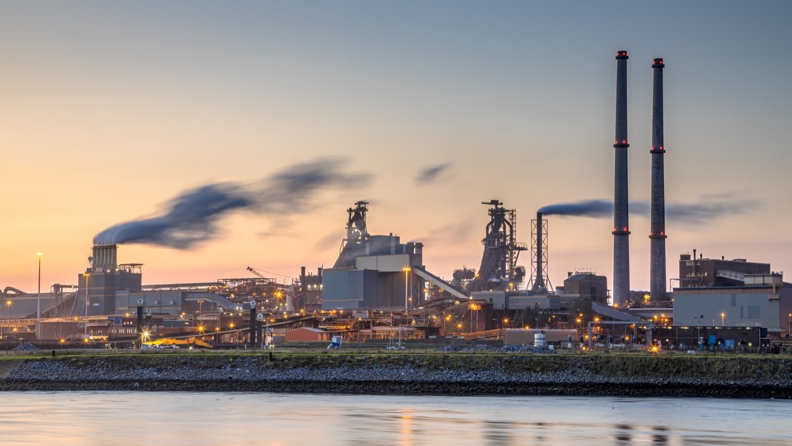 Usine sidérurgique en bord d'eau au coucher du soleil