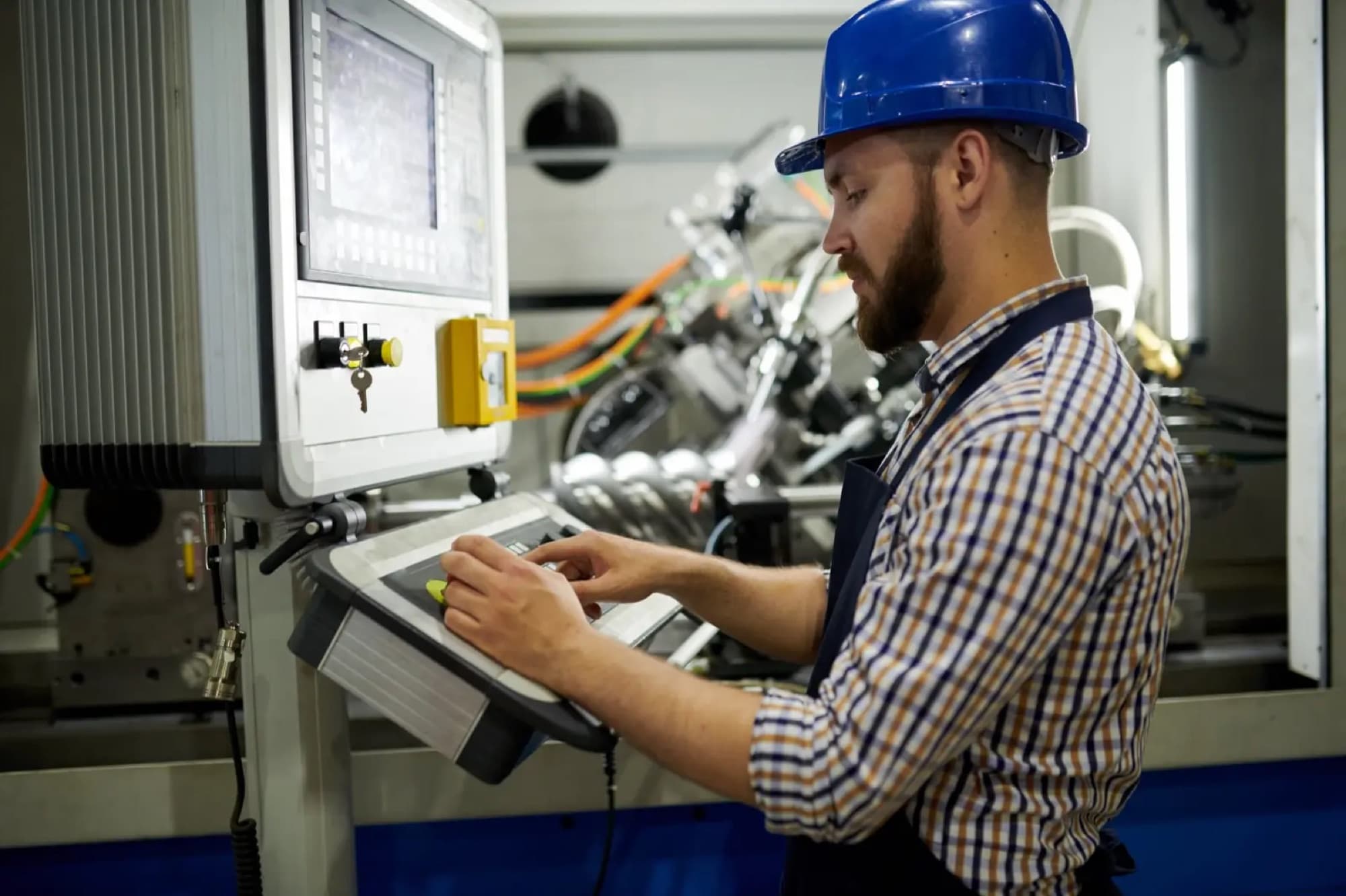 Régleur programmant le pupitre à commande numérique d'une machine-outil en atelier