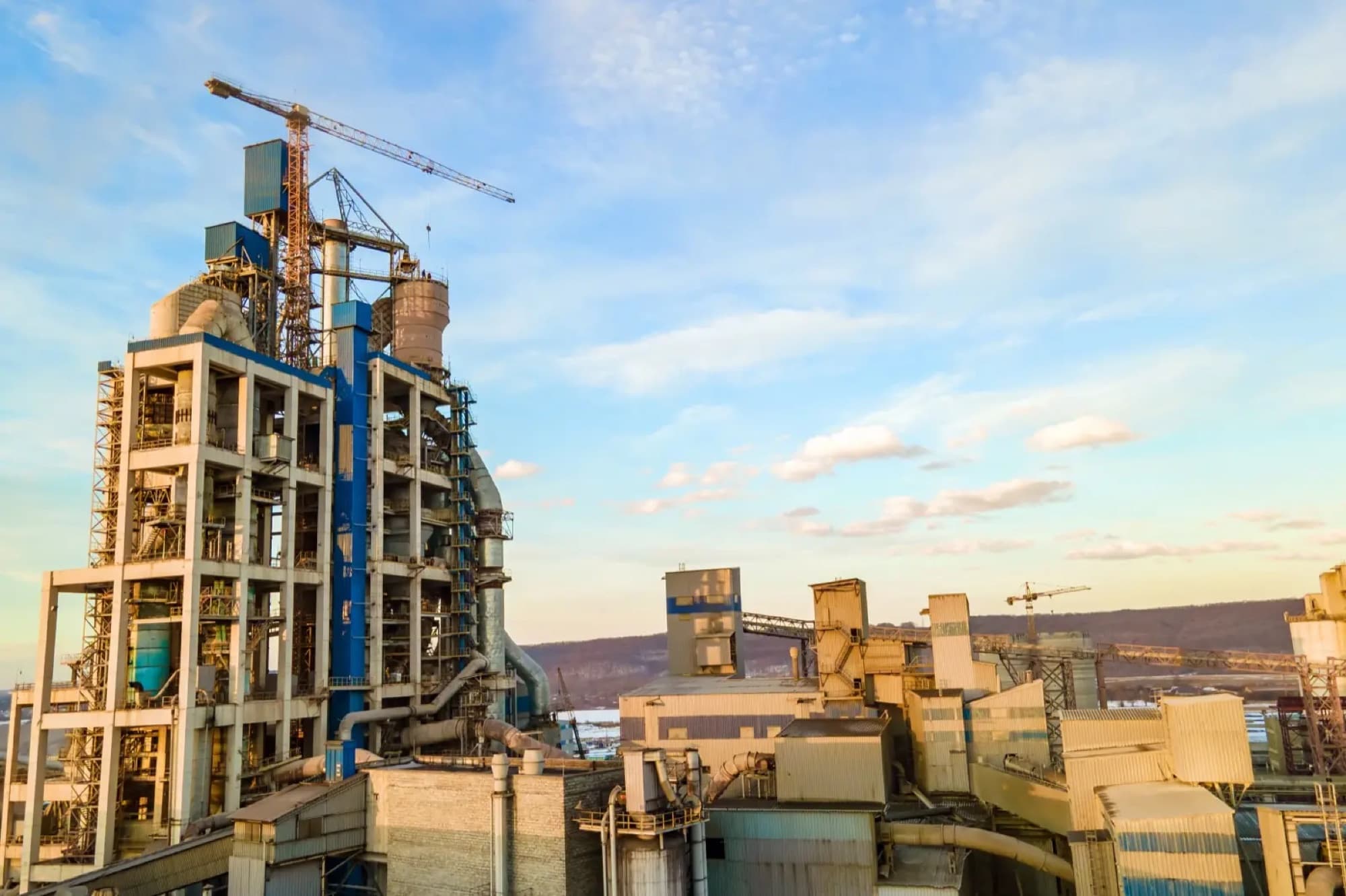 Cimenterie vue de haut, tour de préchauffage en béton, bâtiments de broyage et grues à tour