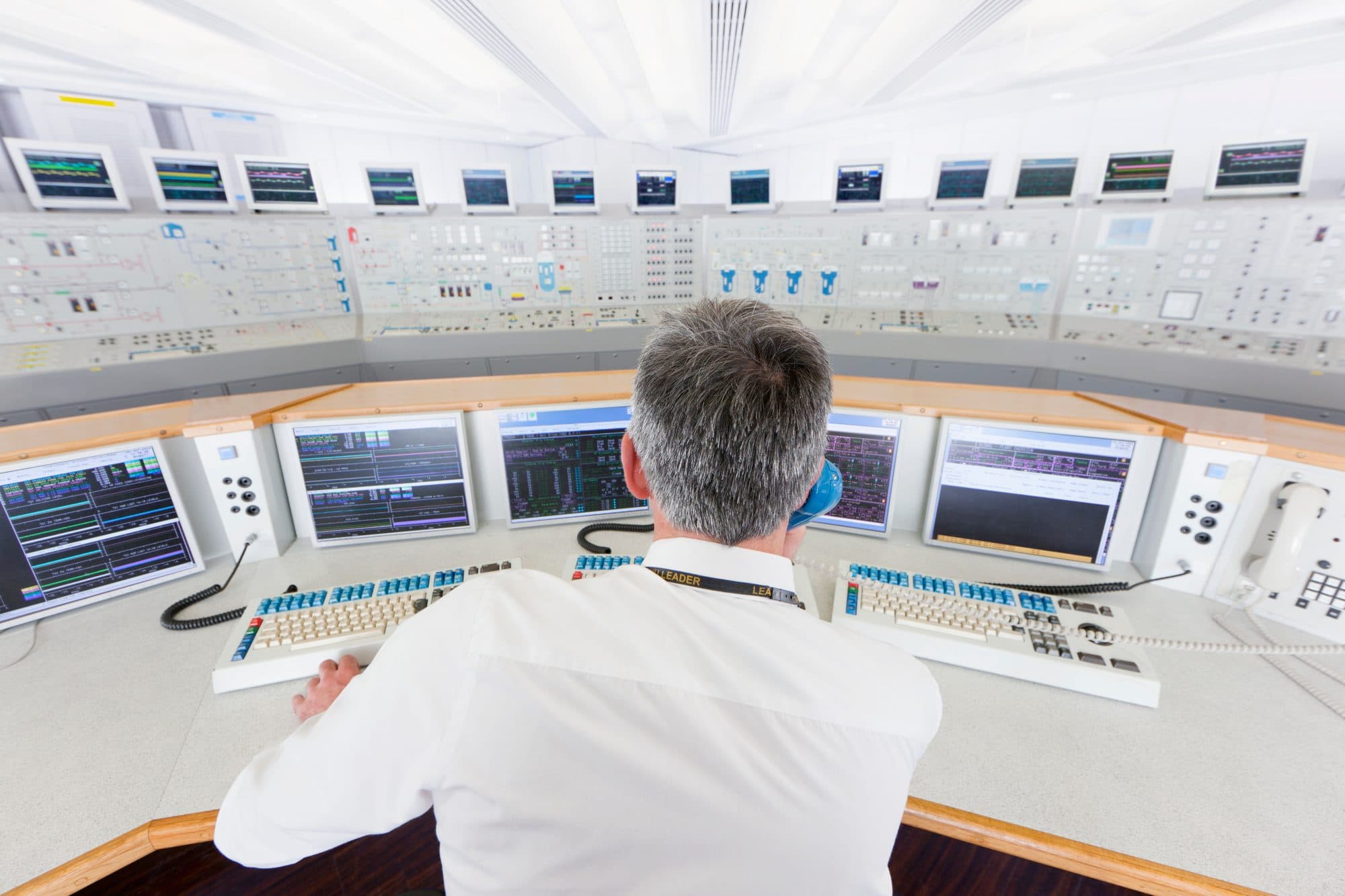 Salle de commande de centrale, ingénieur senior de dos