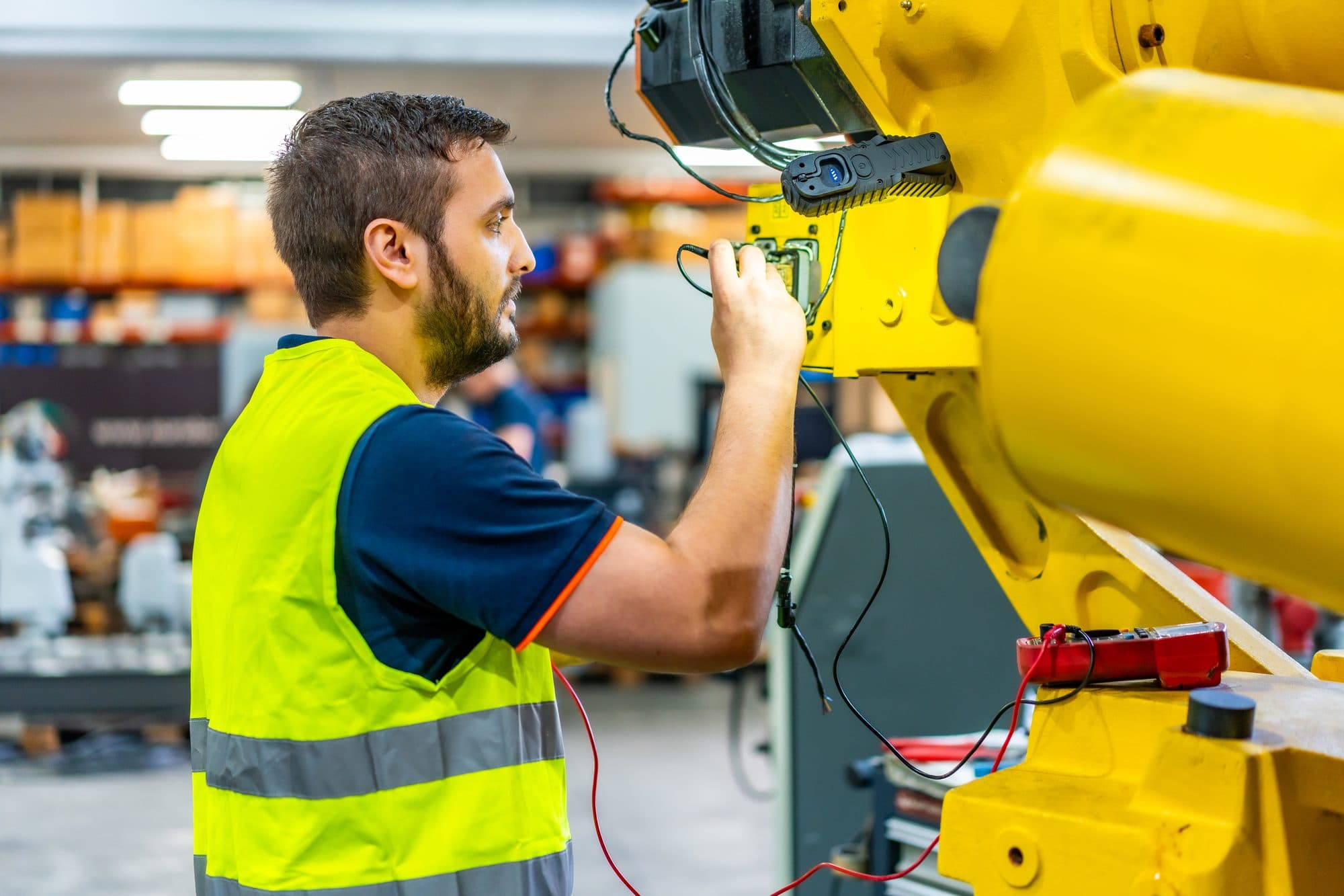 Test au multimètre du câblage d'un robot industriel