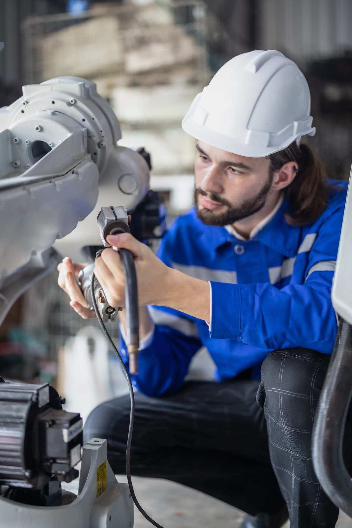 Technicien concentré, les mains sur le poignet d'un robot